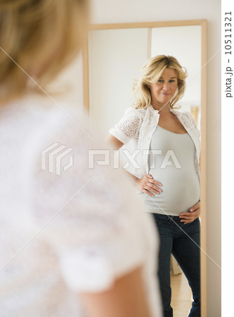 Pregnant woman looking in mirror 10511321