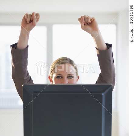 Businesswoman peeking from behind computer 10511399
