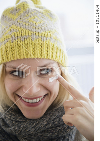 Portrait of smiling woman applying face cream Portrait of smiling woman applying face cream 10511404