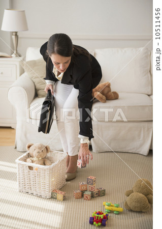 Woman is cleaning toys in living room 10511456