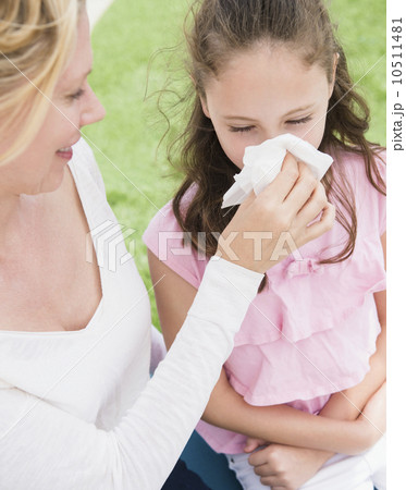 Mother helping daughter (8-9 years) to blow her nose 10511481