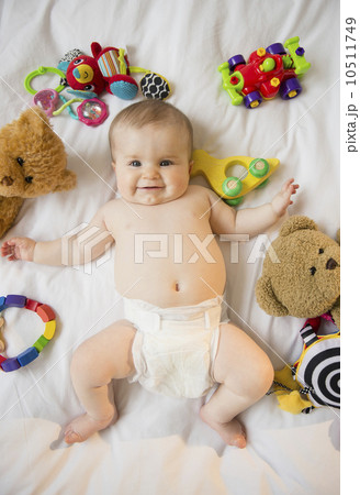 Portrait of baby girl (6-11 months) lying down among toys 10511749