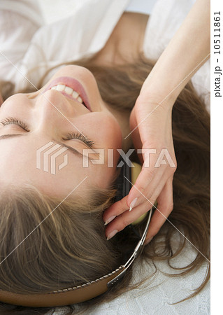 Woman lying on bed and listening to the music Woman lying on bed and listening to the music 10511861