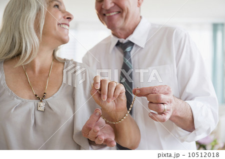 Man putting on bracelet on woman's hand 10512018
