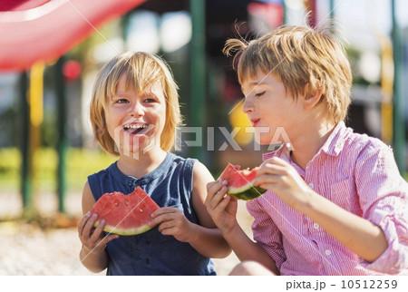 Boys (4-5, 8-9) playing on playground 10512259