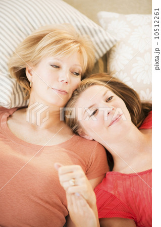 Mother and adult daughter relaxing on floor Mother and adult daughter relaxing on floor 10512261