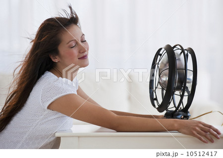 Fan blowing woman's face Fan blowing woman's face 10512417