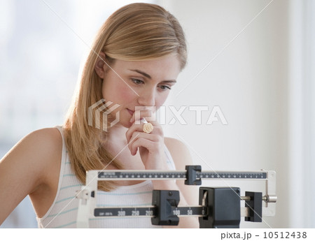 Young woman using measuring scales Young woman using measuring scales 10512438