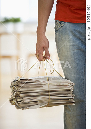 Man holding stack of newspapers 10512494