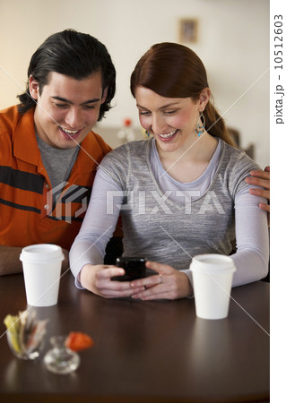 Couple reading text on cellular phone Couple reading text on cellular phone 10512603