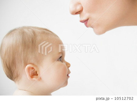 Side view of mother about to kiss her baby daughter (6-11 months) 10512702