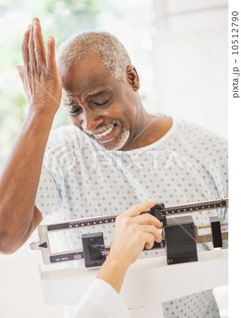 Upset man on weight scale 10512790