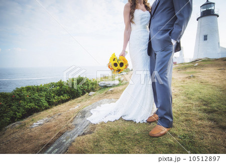 Low section of married couple, lighthouse in background 10512897