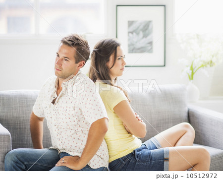 Portrait of sad couple on sofa, back to back 10512972
