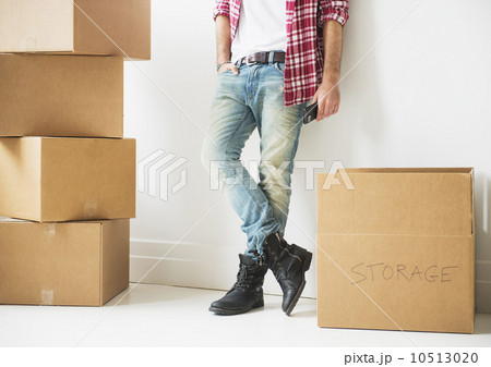 Low section of man next to stack of cardboard boxes Low section of man next to stack of cardboard boxes 10513020