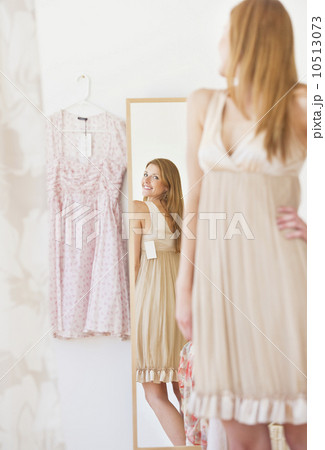 Young woman in clothes shop fitting dress 10513073