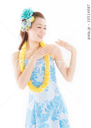 南国ムードたっぷりの華やかなフラの衣装を着て踊る若い日本のキレイな女性の写真素材