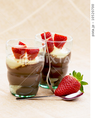 Two glasses with pudding, strawberry and teaspoons 10520700