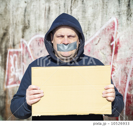 Demonstrator with a tape on a mouth and poster in hands 10526933