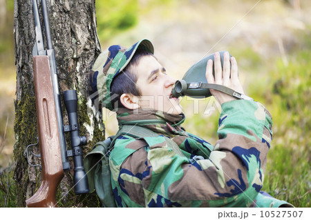 Recruit with water bottle in forest near tree Recruit with water bottle in forest near tree 10527507