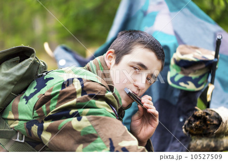 Young recruit with harmonica and rifle in forest Young recruit with harmonica and rifle in forest 10527509
