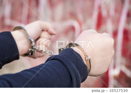 Man with outstretched arms in handcuffs near wall Man with outstretched arms in handcuffs near wall 10527530