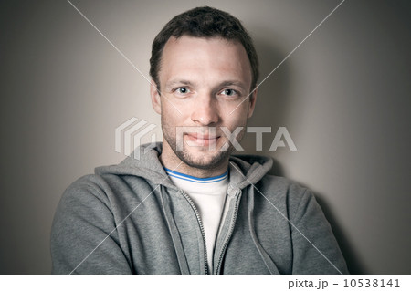 Young smiling Caucasian man in gray sporty jacket with hood Young smiling Caucasian man in gray sporty jacket with hood 10538141