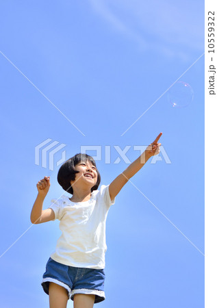 青空で指さす女の子(シャボン玉) 10559322