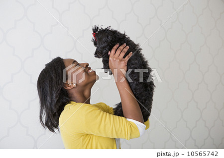 A young girl holding her small black pet dog. A young girl holding her small black pet dog. 10565742