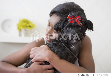 A young girl hugging her small black pet dog. A young girl hugging her small black pet dog. 10565860