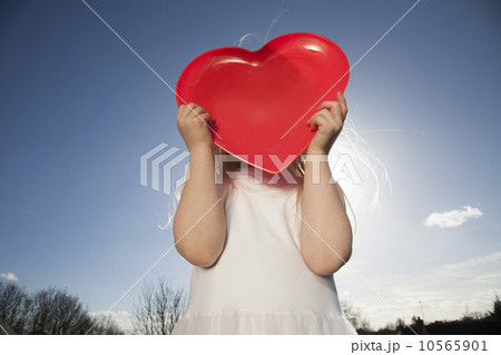 A child holding a red heart shape. 10565901