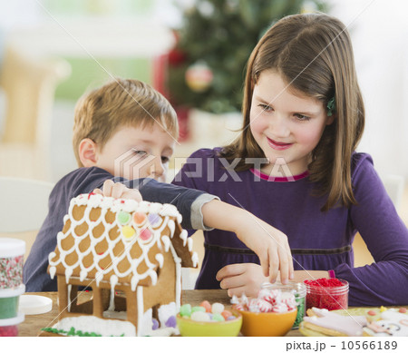 Girl (8-9) and boy (6-7) preparing gingerbread decorations Girl (8-9) and boy (6-7) preparing gingerbread decorations 10566189