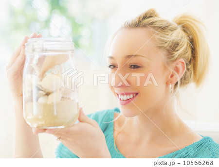 Young woman holding shells in jar Young woman holding shells in jar 10566268