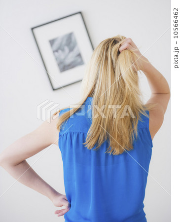 Rear view of woman looking at painting on wall Rear view of woman looking at painting on wall 10566462