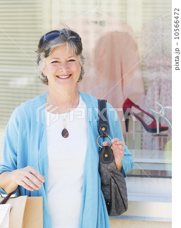 Senior woman standing in front of window display Senior woman standing in front of window display 10566472