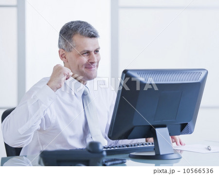 Portrait of happy businessman working at desk 10566536