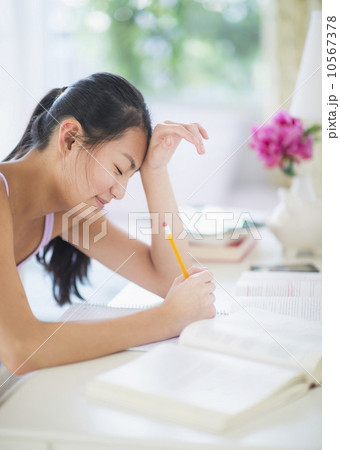 Side view of teenage girl ( 16-17 years) studding 10567378