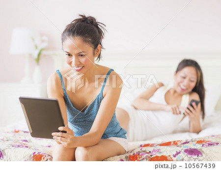 Two women using digital tablet and mobile phone 10567439