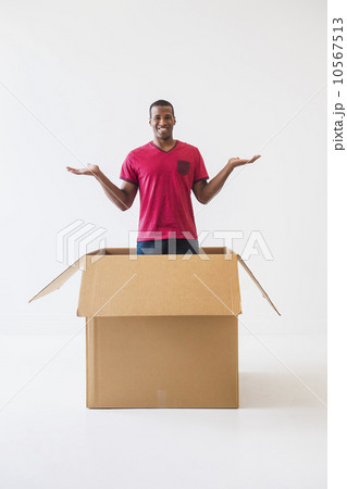 Studio shot of young man with large cardboard box 10567513