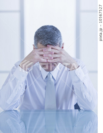 Portrait of depressed businessman sitting at desk 10567527