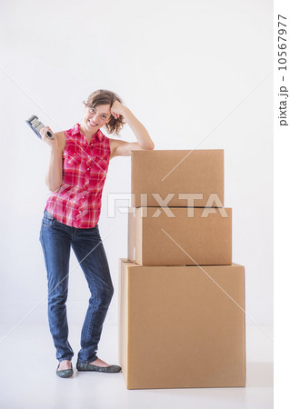 Studio shot of young woman with tape and stack of boxes 10567977