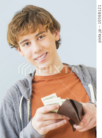 Teenage boy (14-15) counting money and looking at camera Teenage boy (14-15) counting money and looking at camera 10568121