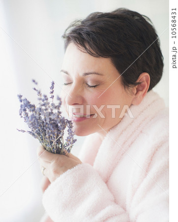 Portrait of mature woman smelling flowers 10568431