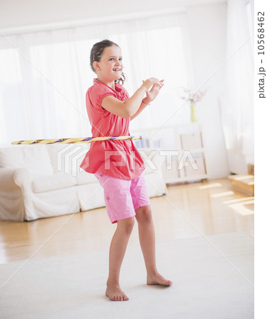 Young girl (8-9) playing with hula hoop Young girl (8-9) playing with hula hoop 10568462