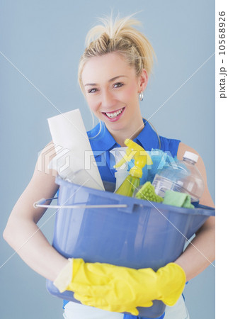 Portrait of young woman carrying cleaning equipment, studio shot 10568926
