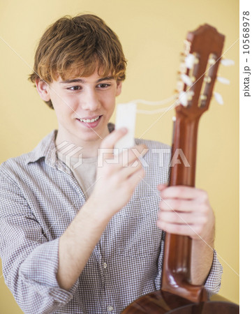 Teenage boy (14-15) with guitar Teenage boy (14-15) with guitar 10568978