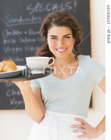 Portrait of smiling waitress with tray against blackboard with menu Portrait of smiling waitress with tray against blackboard with menu 10569195