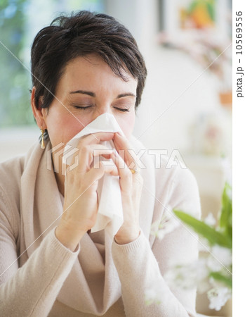Portrait of mature woman blowing nose 10569556