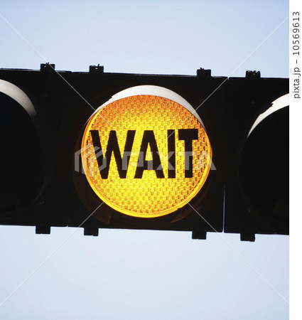 Yellow traffic light reading Wait 10569613