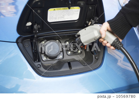 Close-up of man charging electric car 10569780